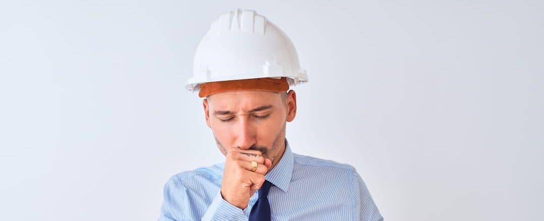 An employee coughing from Sick Building Syndrome.