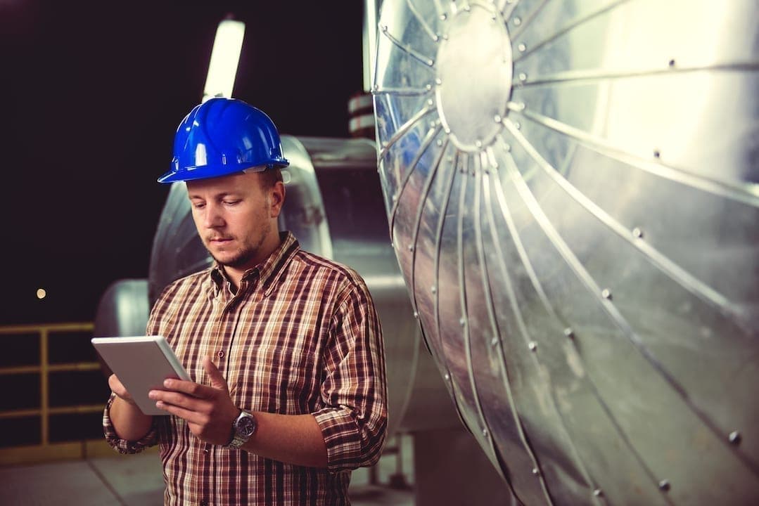 A male technician looking at his current preventive maintenance plan.