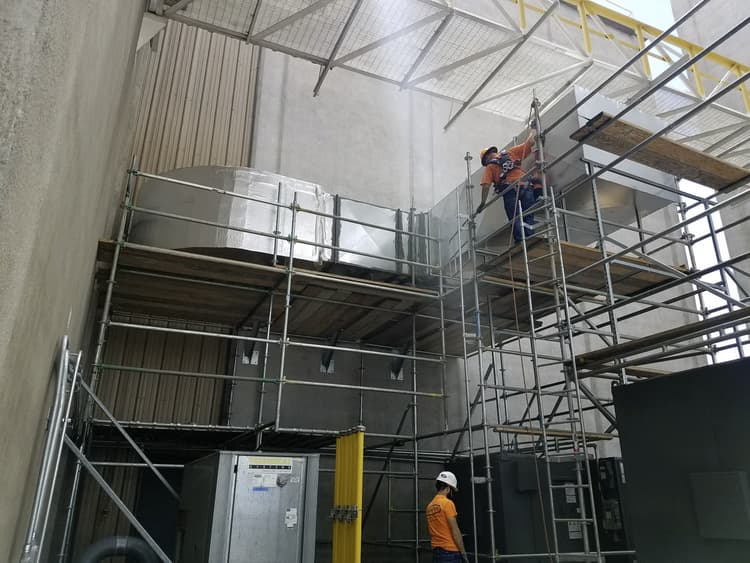 Installing HVAC outside of facility on scaffolding to make-up air units
