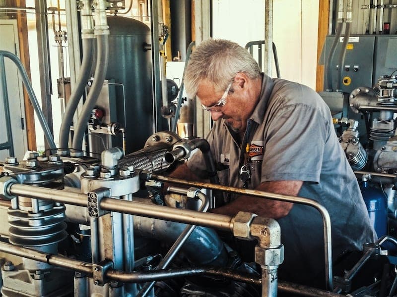 Service Technician looking over a compressed air system