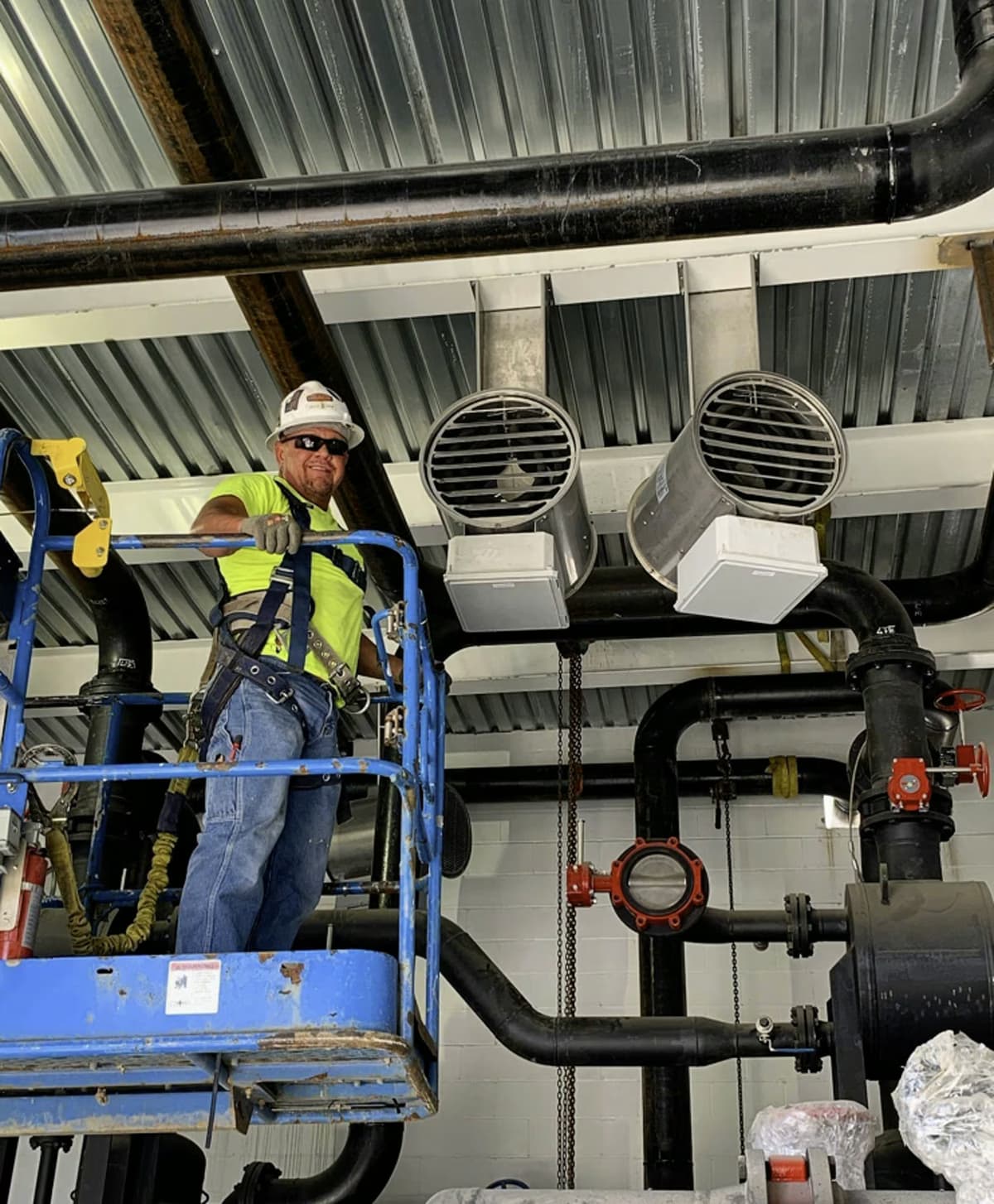 HVAC Tech On A Lift Working On Equipment