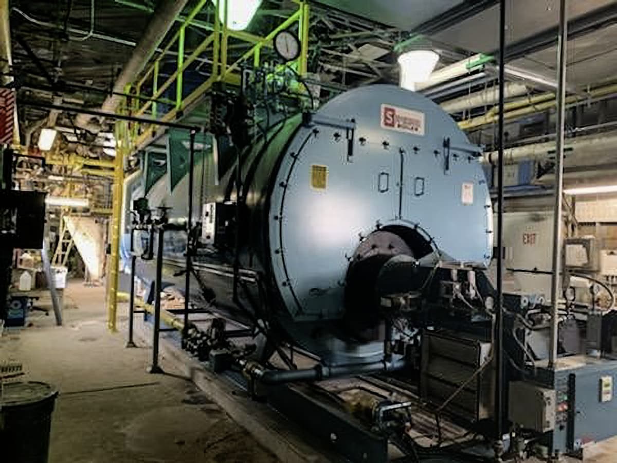 Superior Boiler installed and operating inside an industrial facility with connected piping and control systems.