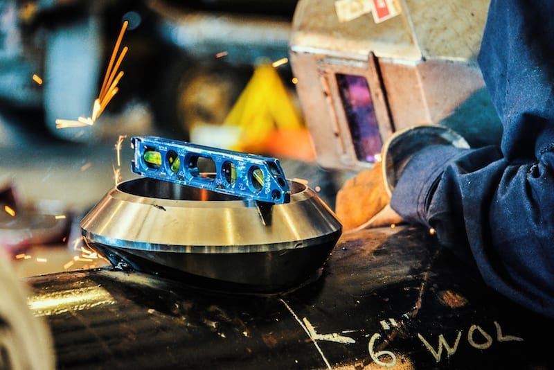 Welder demonstrating mechanical construction services by welding stainless steel