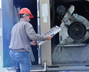 Heating and Cooling Services Technician Replacing a HVAC Filter in the Spring